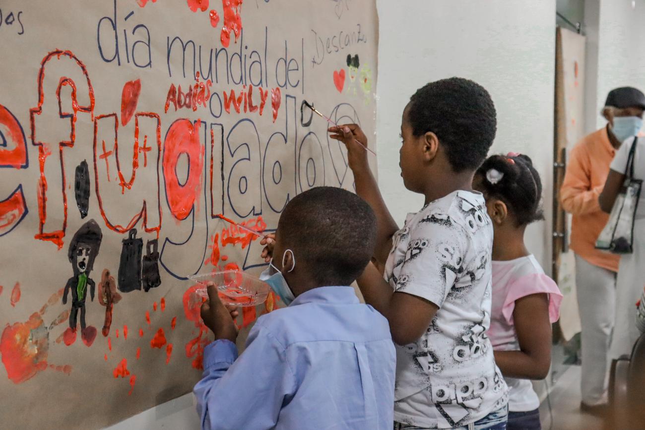 Niños y niñas pintan un mural en favor de personas refugiadas